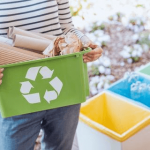 a woman holding a full recycle bin in front of her