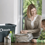 a mother teaching her daughter about how to recycle and showing her what to recycle